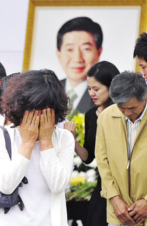 一名悼念卢武铉的韩国人掩面哭泣。
