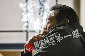 说起儿子非亲生时，李立总会停下来大口抽烟。 记者 贺怀湘 摄