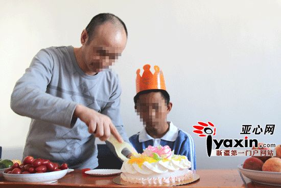图为吴军为儿子切生日蛋糕（亚心网记者 杜疆鸣 摄）