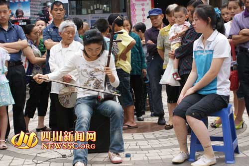 7月12日，流浪二胡女孩刘娟在街头为付华清义演募捐靳廷江摄