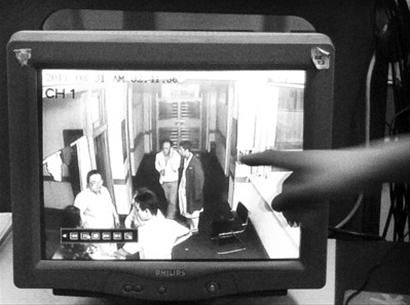 昨日中午，苏秀云老人的亲属在监控录像上指认值班医生(身披深色大衣的男性)。 记者 刘红涛 摄