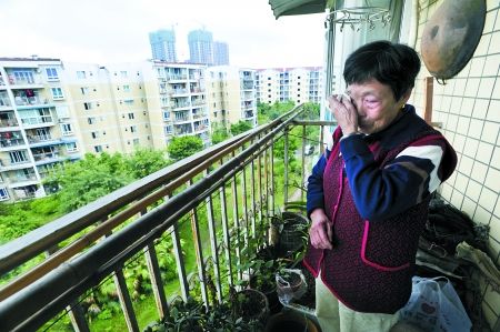 昨日，沙坪坝区曾家，陈婆婆望着对面女儿家的阳台伤心落泪。 记者 吴珊 摄