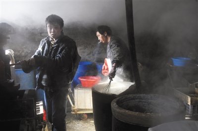 徐庄村一豆腐黑作坊内，两名智障劳工正在劳作。