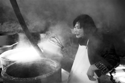 12月3日，徐庄村一豆腐黑作坊内，一名智障女劳工正在做豆腐。
