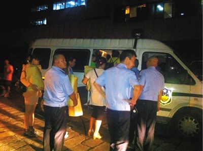 昨晚11时许，被警方带走调查的多名人员手里都拿着物品。 新京报记者 杨锋 摄