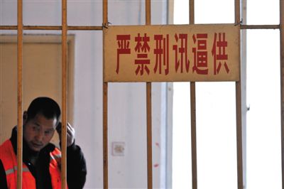 2014年3月18日，<a href=//sc.110.com>四川</a>省成都市，一犯罪嫌疑人在“严禁刑讯逼供”的标牌下接受审讯。图/CFP