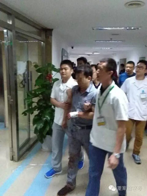 涉嫌砍死女医生的医务人员邓某曾试图自杀，后被控制并从医院带走。 目击者供图