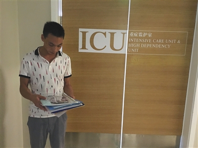 昨日，北大医疗康复医院，小辛怡的父亲张少峰在ICU病房外整理医院单据。新京报记者 李明 摄