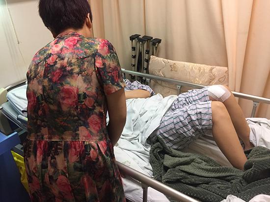黄小妮躺在医院病床上，母亲在身旁照顾。澎湃新闻见习记者 李佳蔚 图