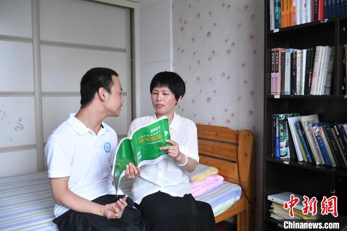 6月27日，汪艾韬和母亲一起在《2021<a href=//ah.110.com>安徽</a>普通高校报考指导》书上用红笔勾出想去的学校。　韩苏原 摄