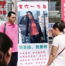 男子为挽回女友感情在街头举海报示爱