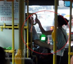 公交司机边开车边与年轻女子搂腰亲热(图)