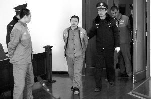 昨日，何某（中）等4人被带入法庭，接受法官质询。本报记者 秦斌 摄 