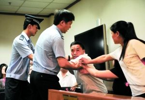 昨日上午庭审时，被害人父亲在法庭上激动地要打被告人。本报记者 王贵彬 摄
