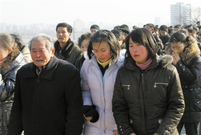 19日，朝鲜民众聚集到平壤市中心万寿台金日成主席铜像前，对金正日逝世表示哀悼。 新华社记者 张利 摄