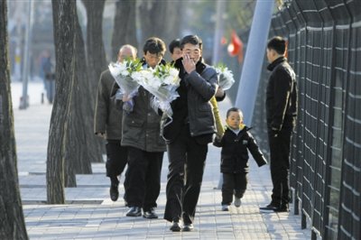 19日，朝鲜民众赴朝鲜驻华使馆献花悼念金正日。